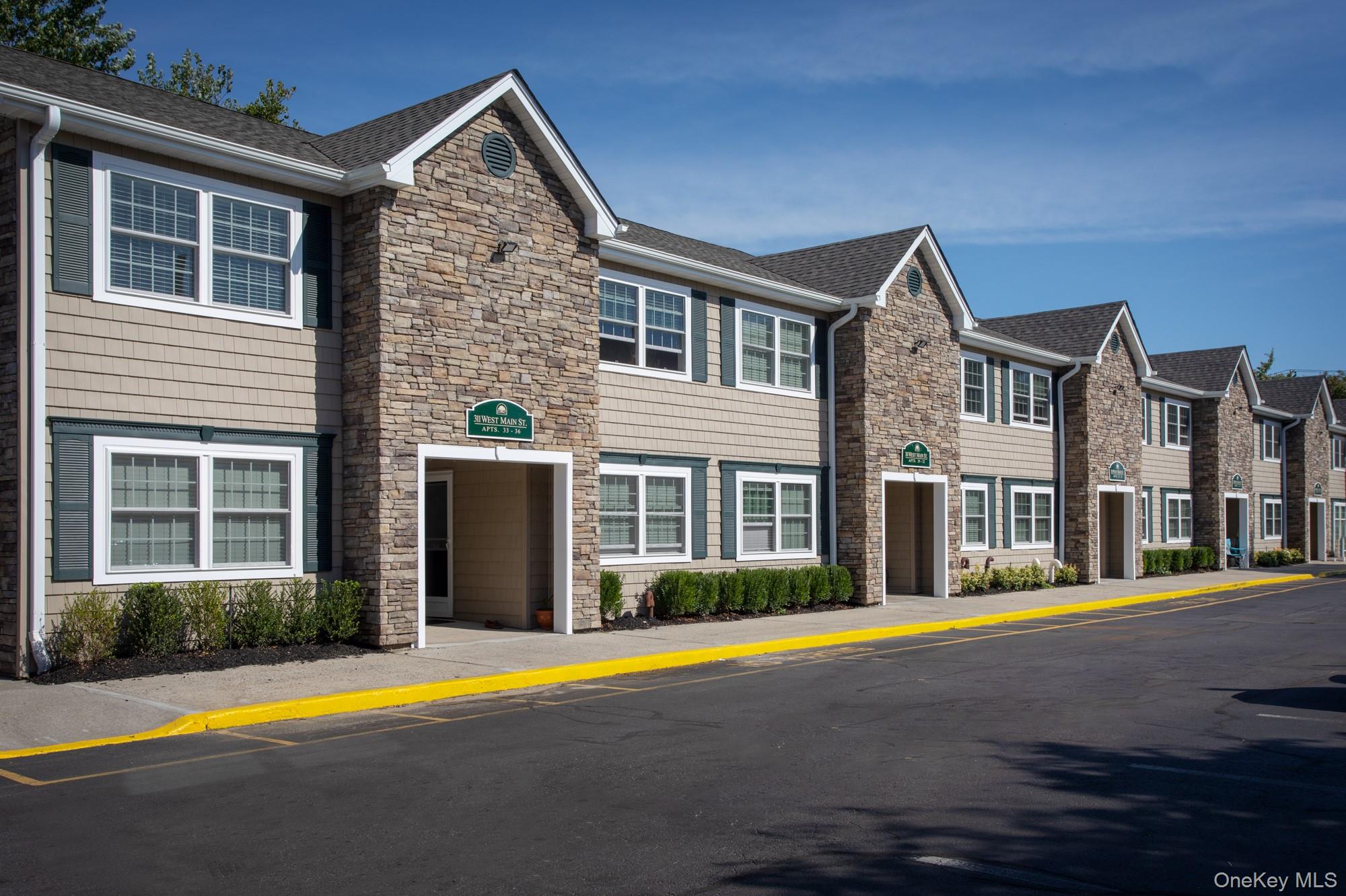 311 West Main Street, Unit 12 Patchogue, NY 11772 - Photo 2 of 8 a front view of multiple houses with yard