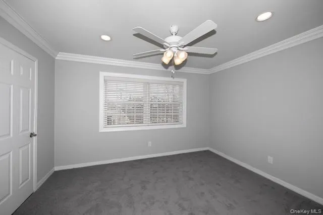 an empty room with a window and ceiling fan