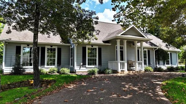 a front view of a house with porch and garden