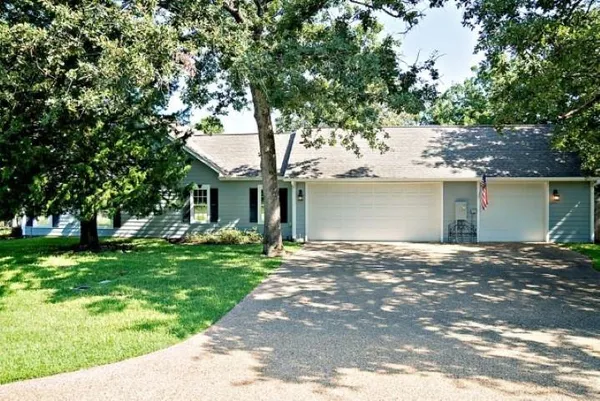 a front view of a house with a garden and trees