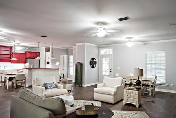 a living room with furniture kitchen view and a chandelier