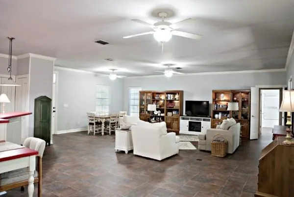 a living room with furniture a chandelier and a flat screen tv