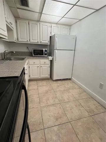a kitchen with a stove a refrigerator and cabinets