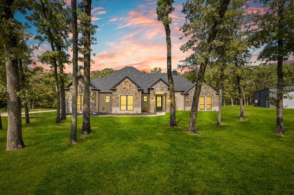 a view of an house with backyard and a tree