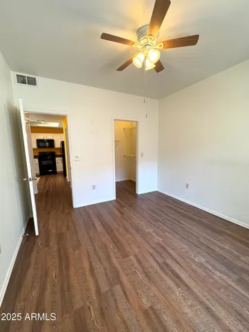 a view of a room with wooden floor and ceiling fan