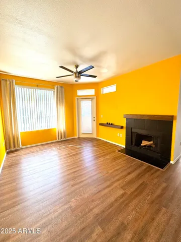 a view of empty room with a fireplace and wooden floor