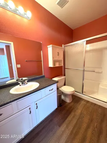 a bathroom with a granite countertop sink toilet a mirror and shower