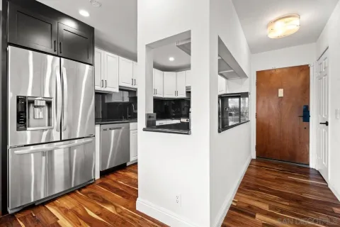 a large kitchen with a large counter space and wooden floor