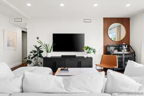 a living room with furniture a flat screen tv and a window