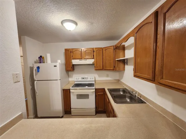 a kitchen with stainless steel appliances granite countertop a refrigerator a stove a sink and a microwave