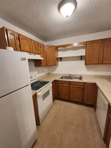 a kitchen with granite countertop a sink and white cabinets