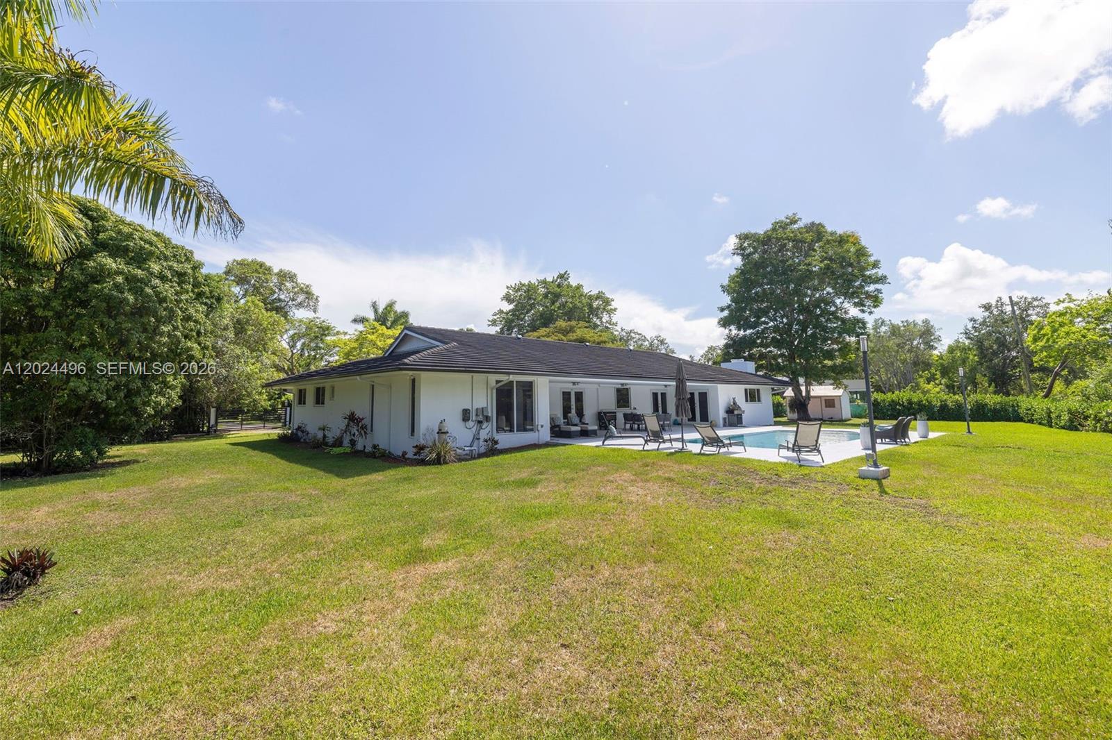 6875 North Cartee Road Palmetto Bay, FL 33158 - Photo 40 of 42 a view of a house with a big yard and palm trees