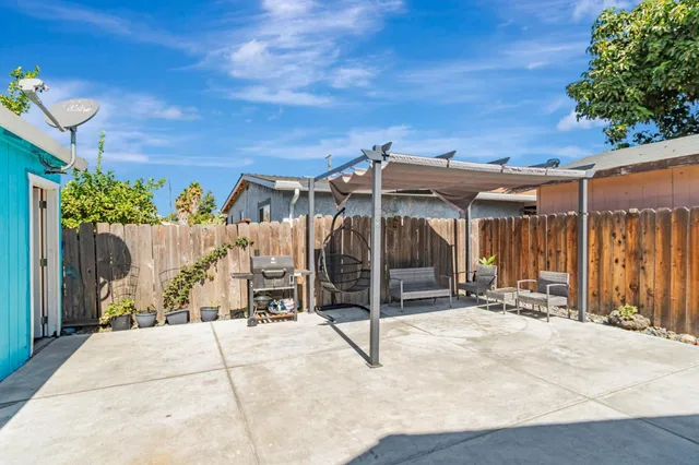 a view of a patio with a table and chairs under an umbrella