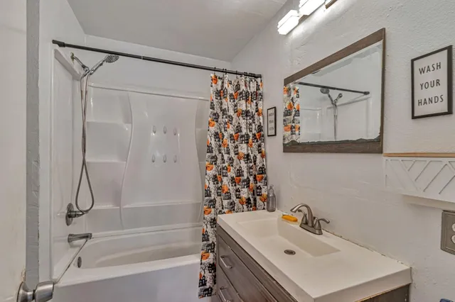 a bathroom with a sink mirror and shower