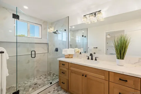 a bathroom with a double vanity sink mirror and shower