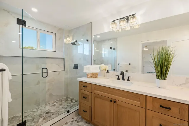 a bathroom with a double vanity sink mirror and shower
