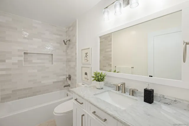 a bathroom with a granite countertop sink a toilet and bathtub