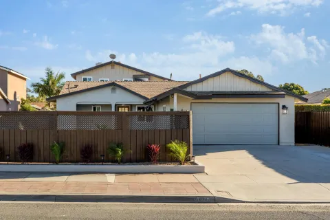 a front view of a house with garage and plants