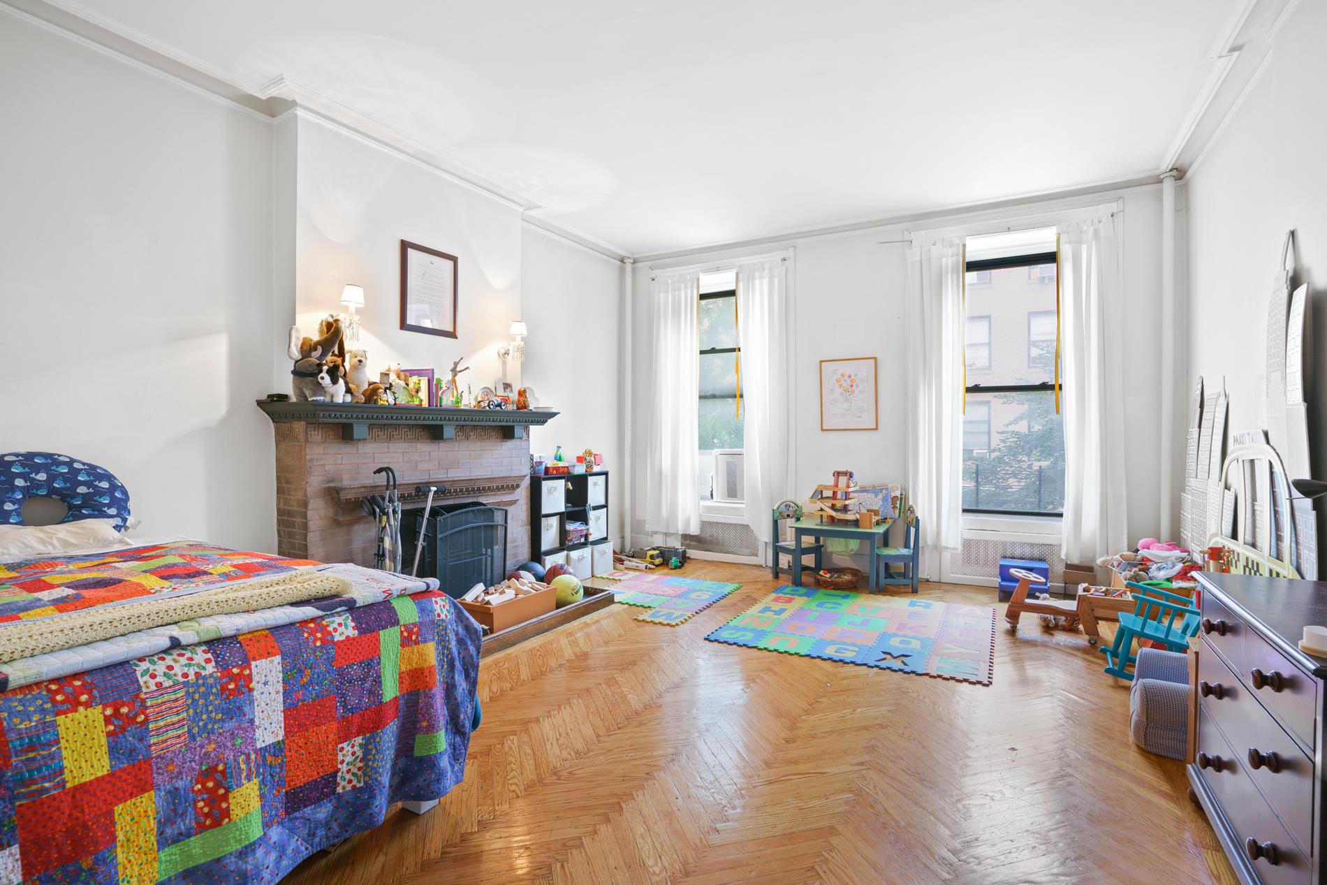 142 East 37th Street, Unit 3 Manhattan, NY 10016 - Photo 7 of 10 a bedroom with a bed and a chandelier