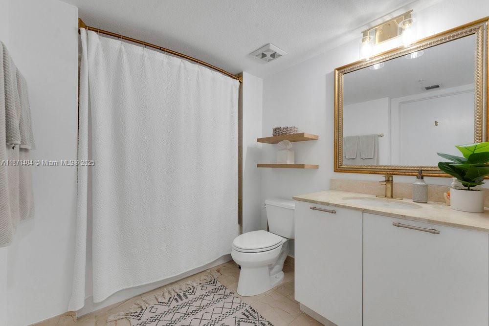 1800 North Bayshore Drive, Unit 614 Miami, FL 33132 - Photo 13 of 29 a bathroom with a sink a toilet and a mirror