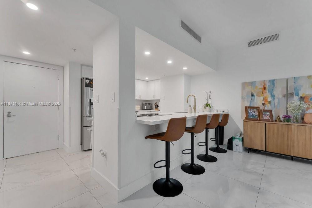 1800 North Bayshore Drive, Unit 614 Miami, FL 33132 - Photo 5 of 29 a kitchen with stainless steel appliances kitchen island granite countertop a refrigerator and a sink