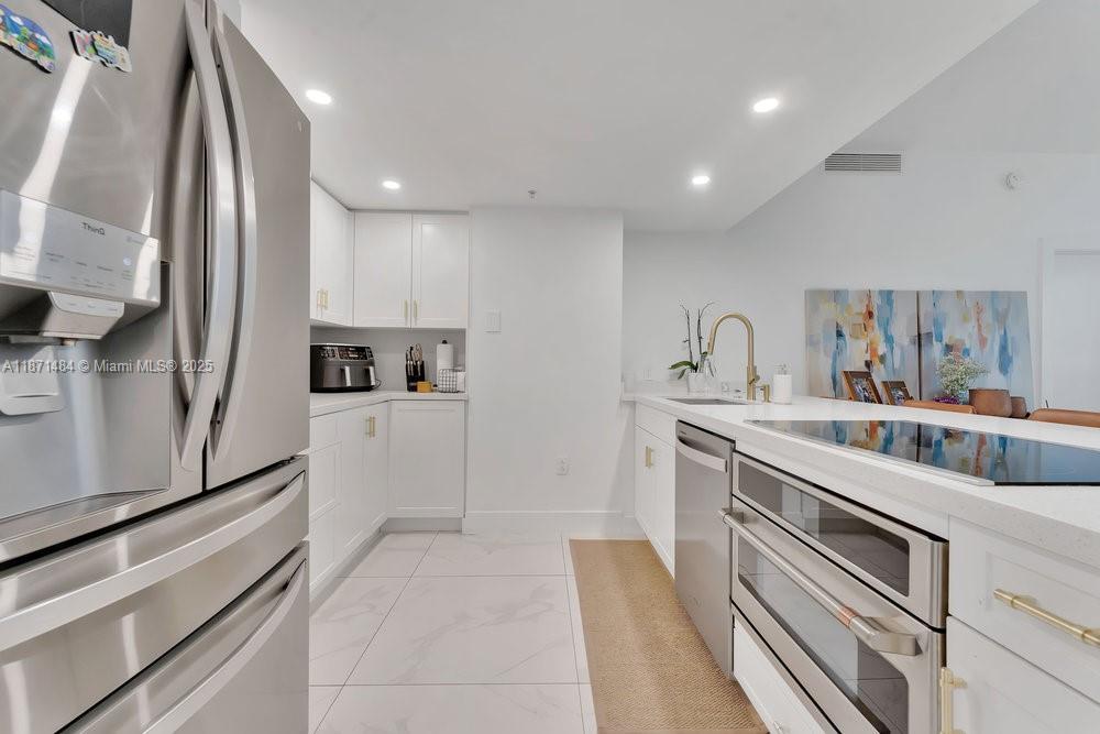 1800 North Bayshore Drive, Unit 614 Miami, FL 33132 - Photo 6 of 29 a kitchen with a sink stainless steel appliances and cabinets