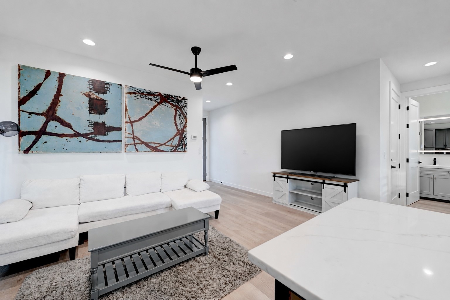 2220 Yellow Jacket Lane, Unit 1 Austin, TX 78741 - Photo 2 of 35 Recessed lighting illuminates an open-concept living space with light-toned flooring and a modern ceiling fan.