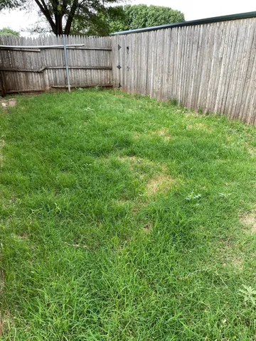 a view of a backyard with a small fence