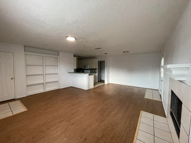 a view of empty room with cabinet and fireplace