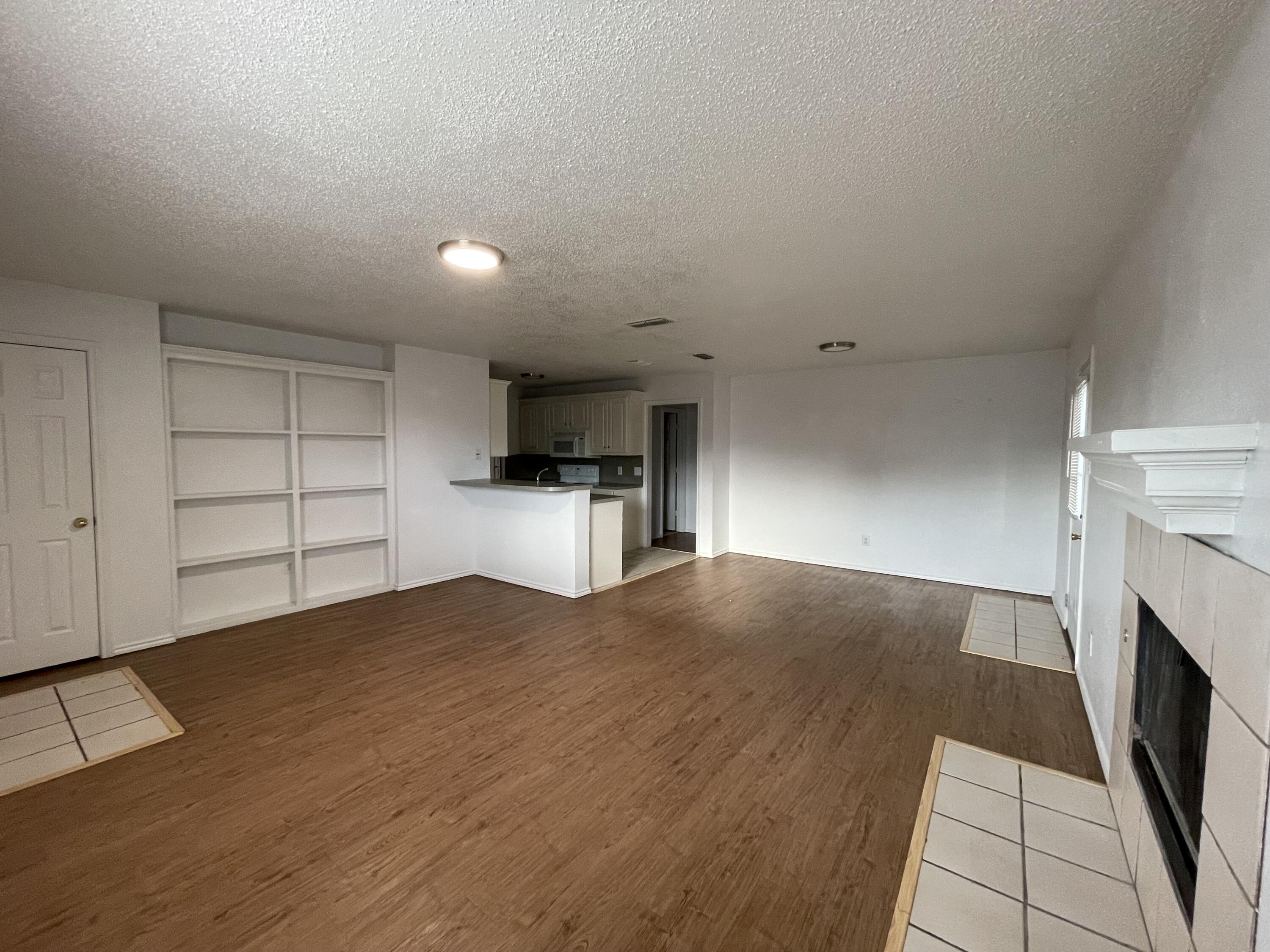 2344 78th Street Lubbock, TX 79423 - Photo 3 of 13 a view of empty room with cabinet and fireplace