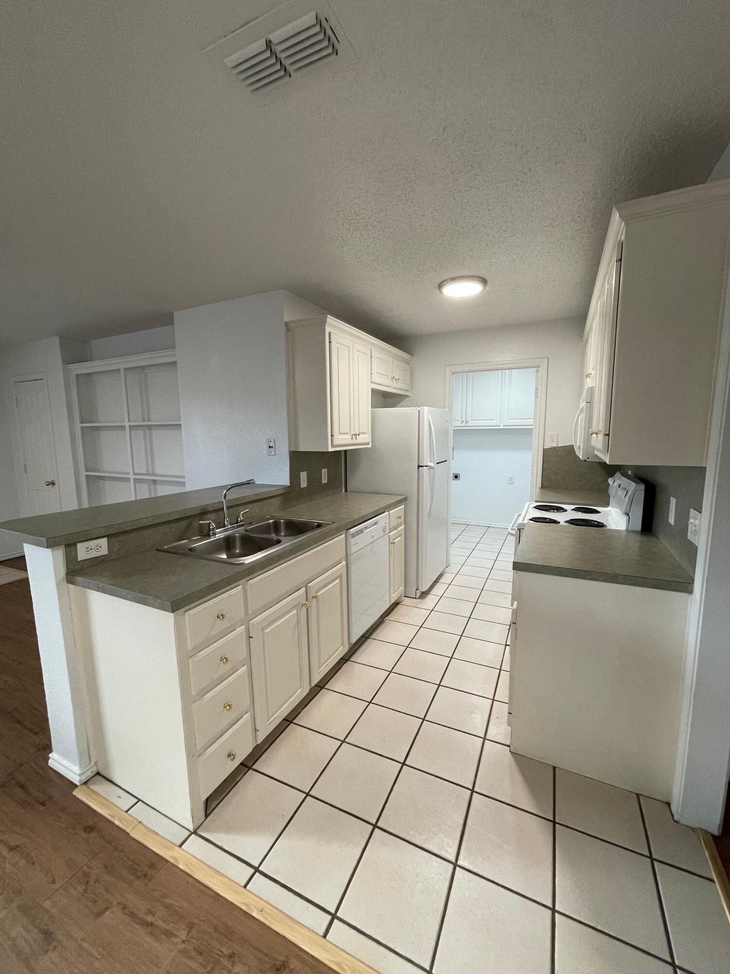 2344 78th Street Lubbock, TX 79423 - Photo 5 of 13 a kitchen with stainless steel appliances granite countertop a stove a sink and a refrigerator