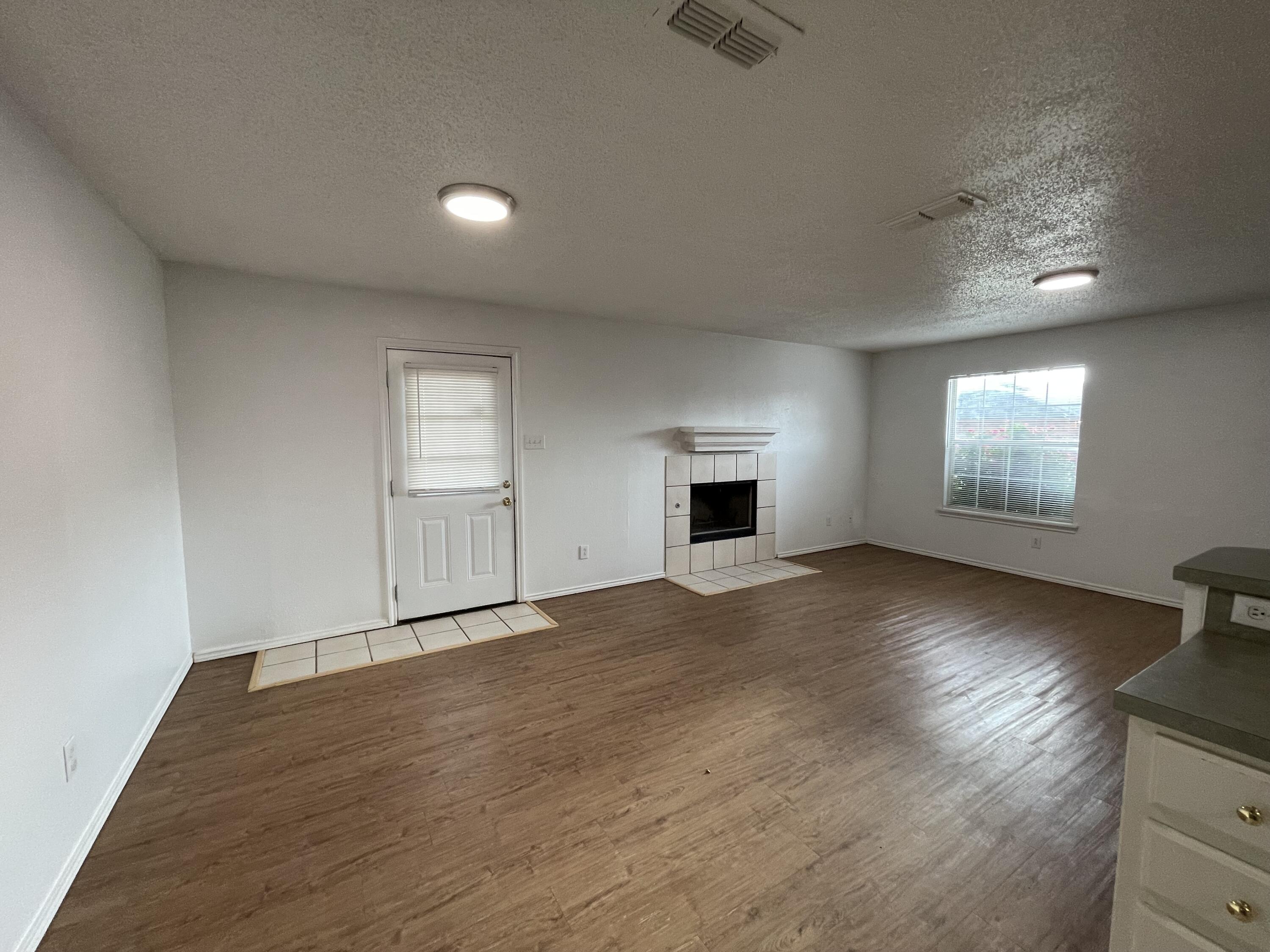 2344 78th Street Lubbock, TX 79423 - Photo 7 of 13 an empty room with windows and fireplace