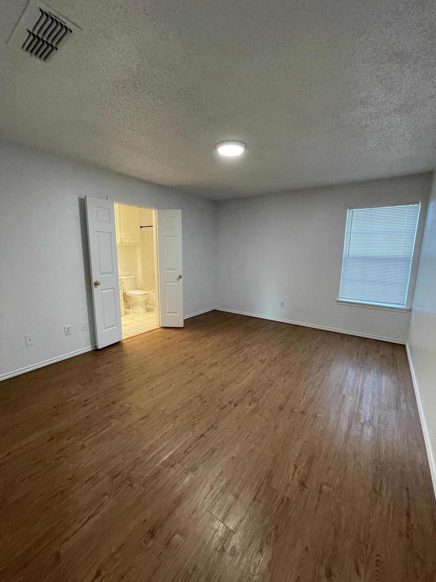 2344 78th Street Lubbock, TX 79423 - Photo 9 of 13 an empty room with wooden floor and windows