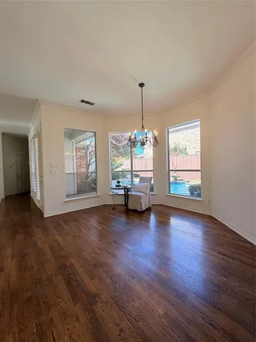 a view of empty room with wooden floor and window