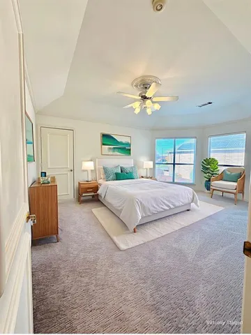 a bedroom with a large bed and ceiling fan