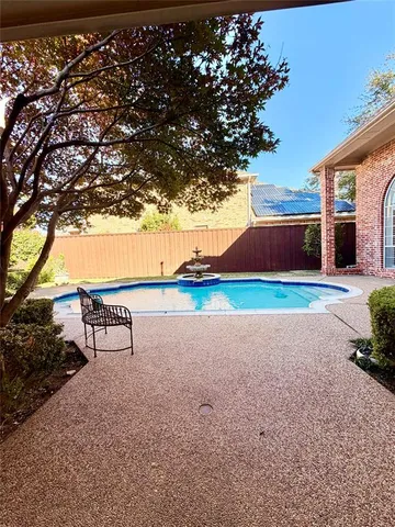 a view of pool and bench in front of house