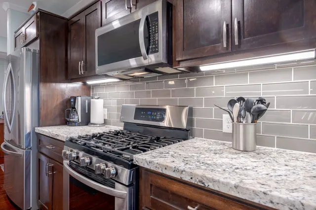 a large kitchen with kitchen island a stove a sink a dining table and chairs