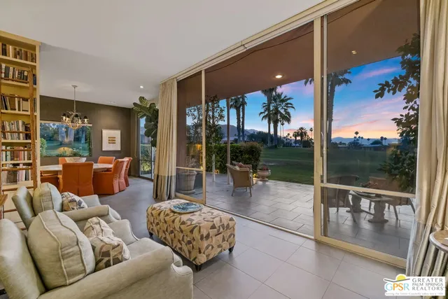 a view of a patio with couches table and chairs potted plants and palm tree
