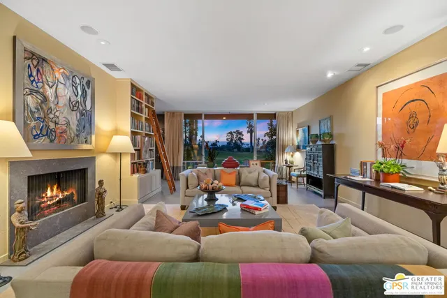 a living room with furniture large window and a fireplace