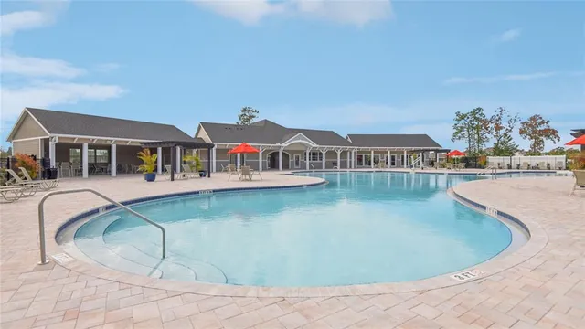 a view of a house with swimming pool and sitting area