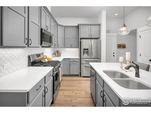 a kitchen with kitchen island granite countertop a sink a counter space appliances and cabinets