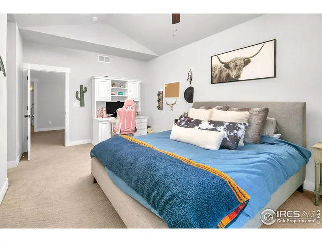 a bedroom with bed and a painting on the wall