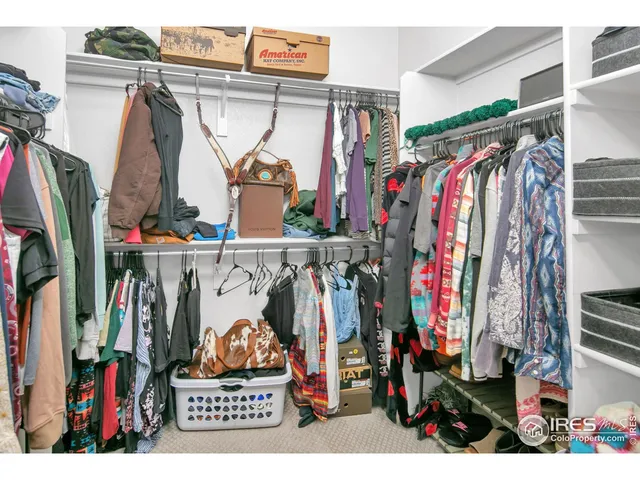 a view of walk in closet with clothes