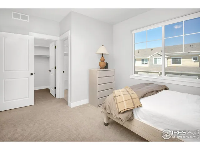 a spacious bedroom with a bed and a cabinets