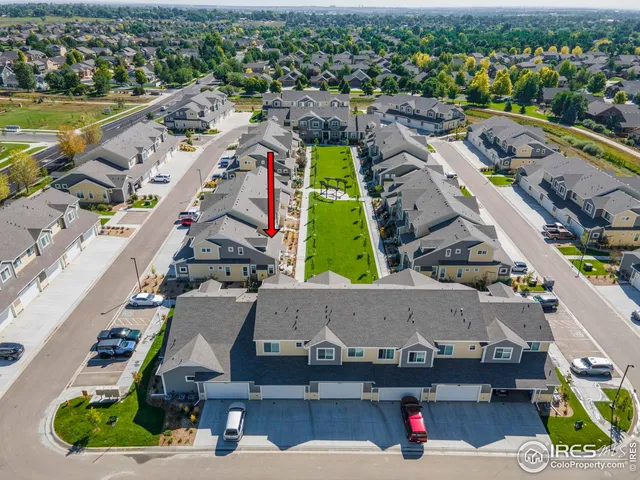 an aerial view of a city with lots of residential buildings ocean and mountain view in back