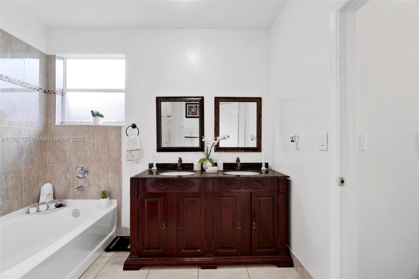 10837 Southwest 246th Street Homestead, FL 33032 - Photo 20 of 44 a bathroom with a double vanity sink a mirror and bathtub