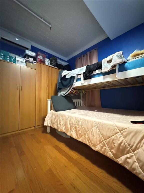 3921 7th Avenue Brooklyn, NY 11232 - Photo 10 of 17 a bed sitting in a bedroom next to a window