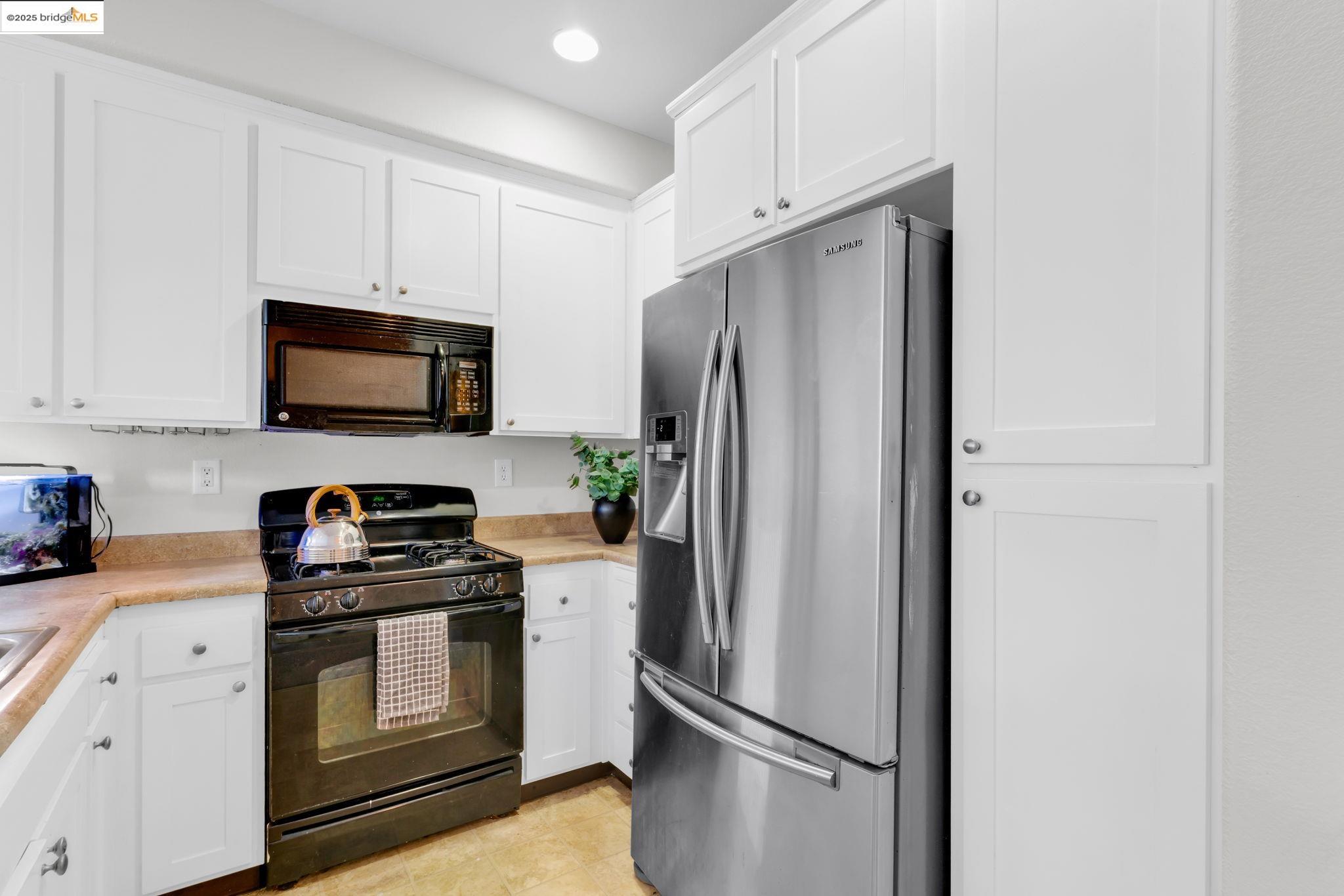 6063 Old Quarry Loop Oakland, CA 94605 - Photo 12 of 36 a kitchen with stainless steel appliances a refrigerator stove and microwave