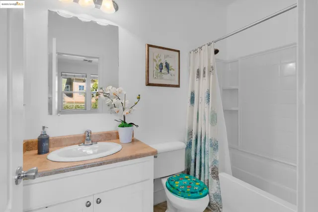 a bathroom with a granite countertop sink a mirror a vanity and a shower