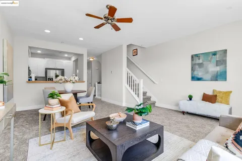 a living room with furniture kitchen view and a potted plant